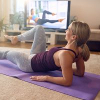 Female athlete practicing her lower abs during home workout.